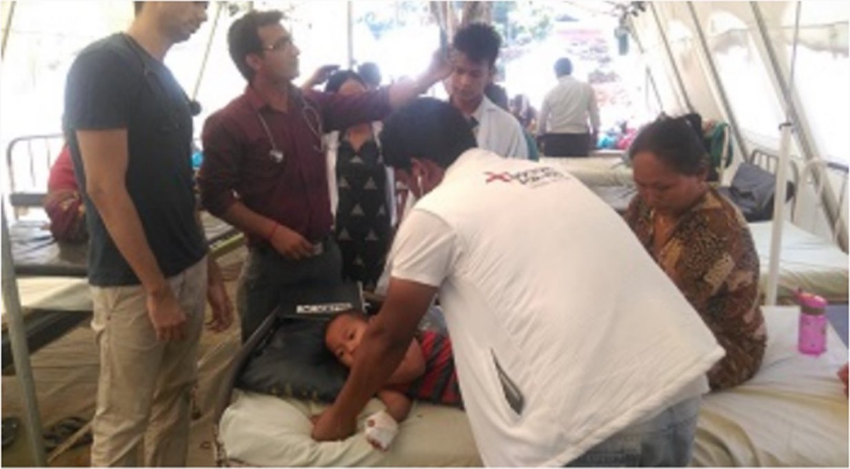 DFY doctors examining a child in a field hospital tent, 2015