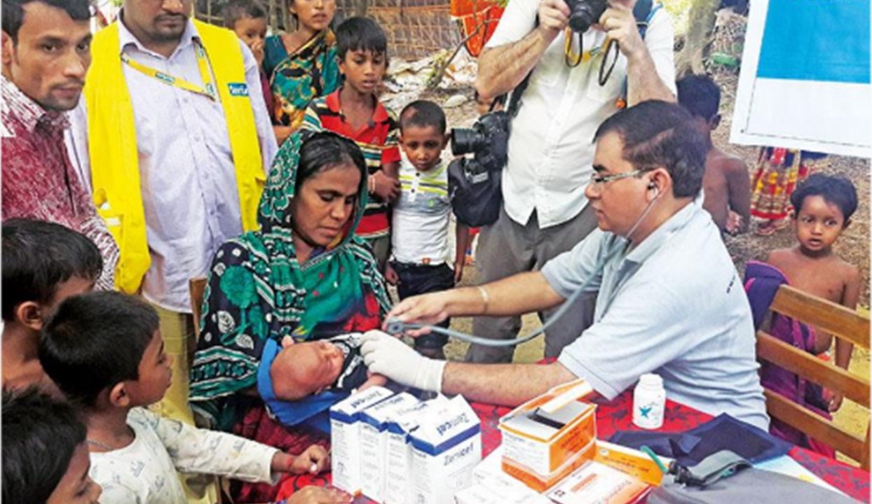 A DFY doctor examining an infant at a Rohingya medical camp