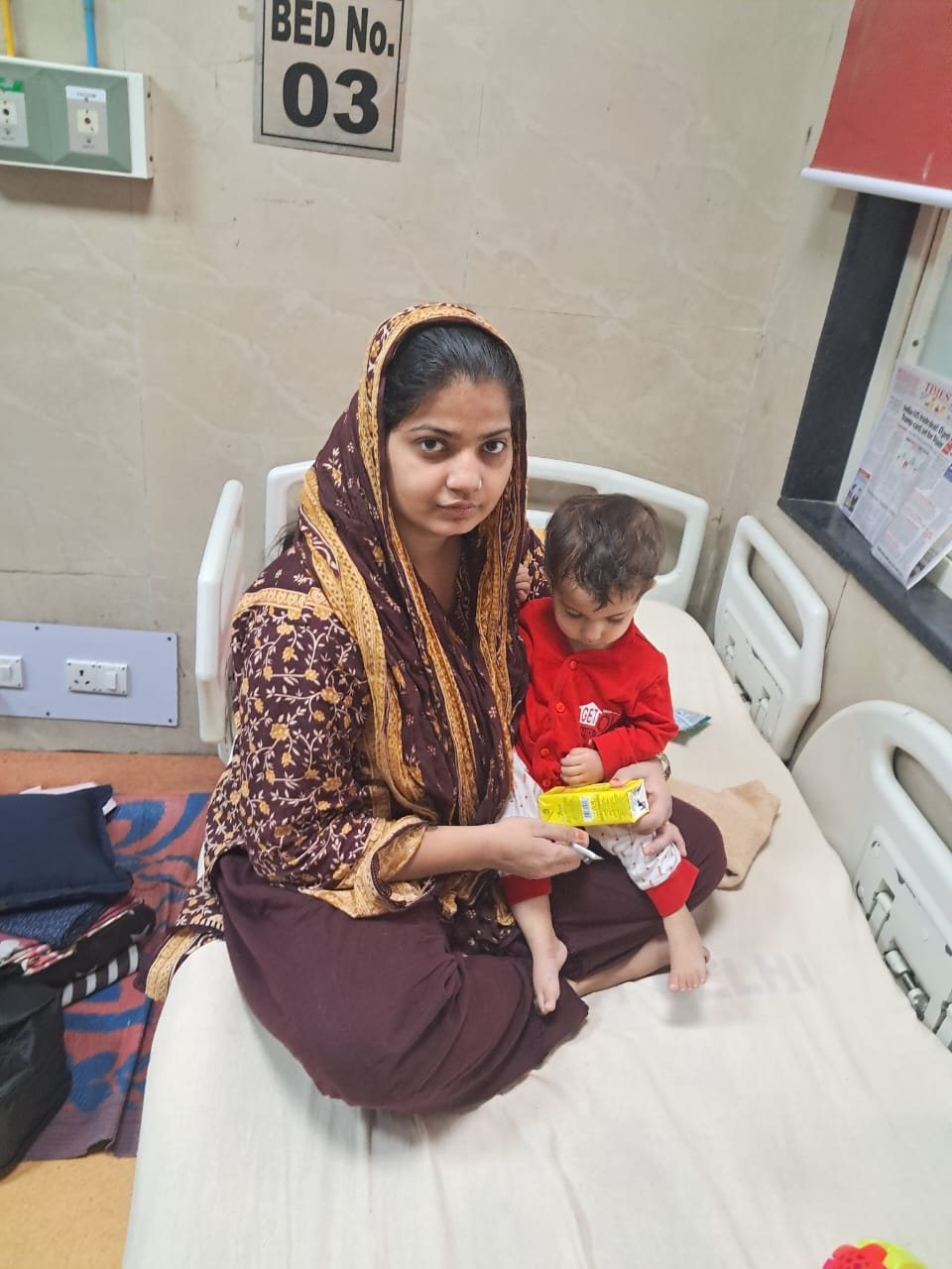 A mother holding her child on the paediatric ward